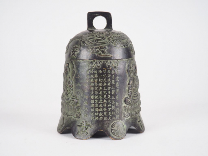Cloche de temple en bronze, légère patine verte à décor ciselé de troi