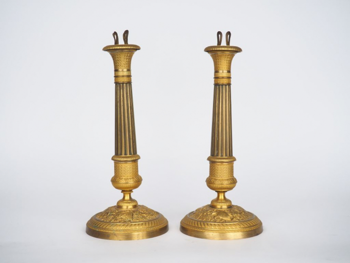 Paire de bougeoirs Restauration en bronze doré et laiton à décor de ca