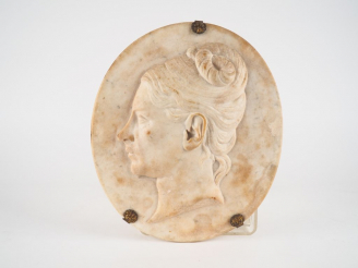 Vente aux enchères ROMAND. Plaque ovale en albâtre sculpté figurant un profil de jeune fe