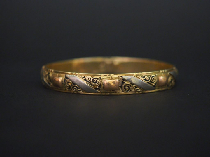Bracelet jonc trois tons d’or, à décor de filigranes. Diam. 6,3 cm Lar
