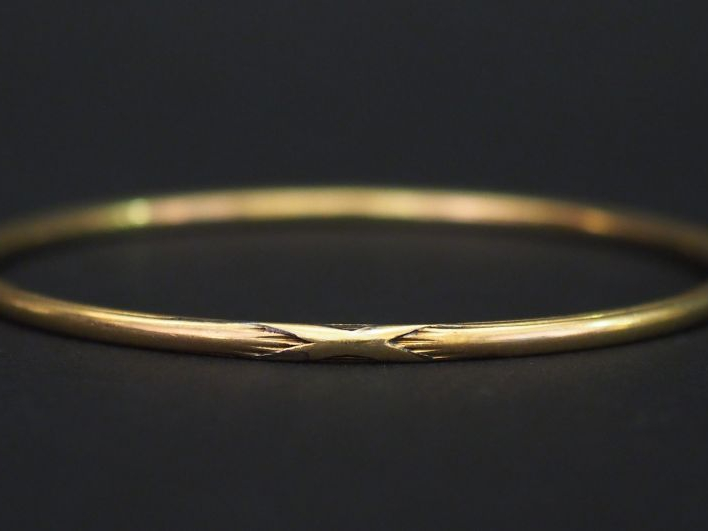 	Jonc en or jaune, à décor de tiges enrubannées. Diam. 6 cm Poids. 17,