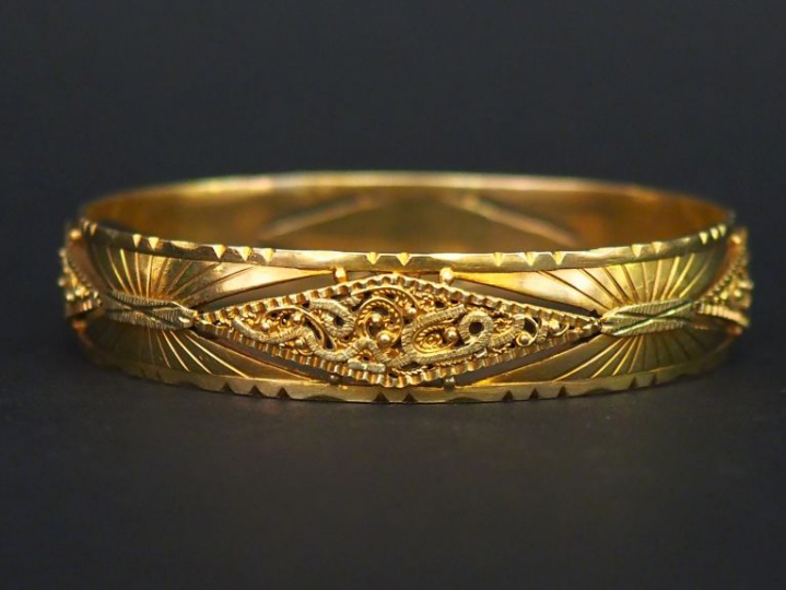 Bracelet jonc en or jaune, à décor ajouré et filigrané. Diam. 6,4 cm L