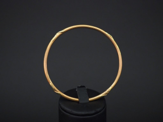 Vente aux enchères Bracelet jonc en or jaune, à décor de tiges enrubannées. Diam. 6,1 cm 