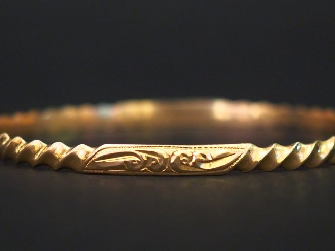 	Bracelet jonc en or jaune, à décor de cotes torses et motifs abstrait