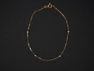 Vente aux enchères Petit bracelet en or jaune, à décor de quatre boules. Long. 17,5 cm Po
