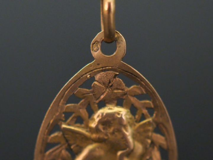 Médaille religieuse en or jaune, à décor ajouré de  branchages fleuris