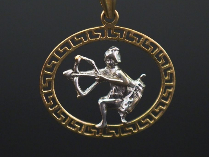 	Pendentif deux tons d’or 14K, à décor ajouré d’un homme tirant à l’ar