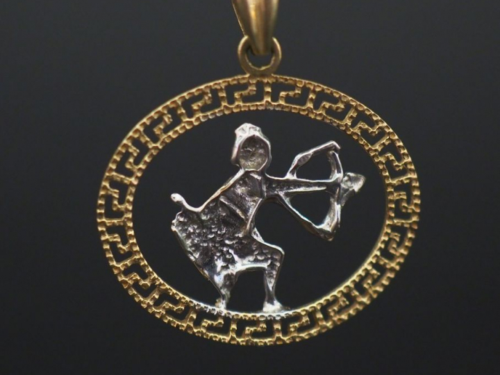 	Pendentif deux tons d’or 14K, à décor ajouré d’un homme tirant à l’ar