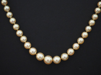 Vente aux enchères Collier de perles disposées en chute. Fermoir en or jaune. Chainette d