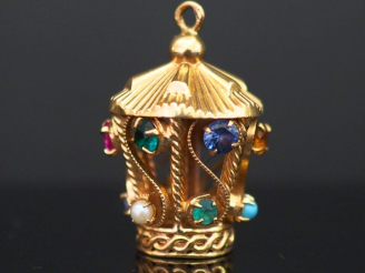 Vente aux enchères 	Pendentif en or jaune, en forme de case, à décor de filigranes, de pi
