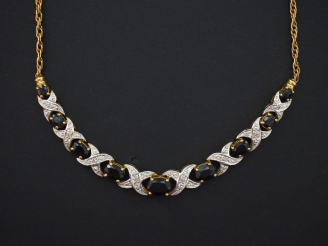 Vente aux enchères Collier en or jaune 9K, retenant des motifs tressés sertis en leur cen