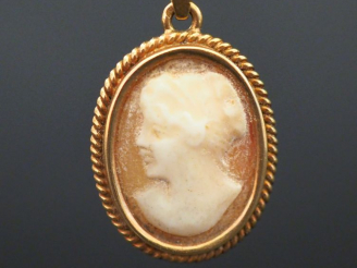 Vente aux enchères 	Pendentif en or jaune, serti en son centre d’un camée figurant une je