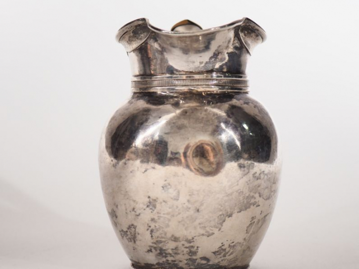 Pot à lait en argent, à décor d'une frise de godrons.  Anse gainée d'o