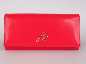 Vente aux enchères Sonia RIKYEL.  Pochette en simili cuir orange, signée.