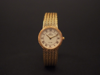 Vente aux enchères OMEGA. Montre bracelet de dame en plaqué or. Signée sur le cadran.