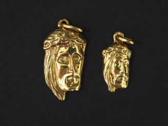 Vente aux enchères Deux pendentifs en or jaune, figurant la tête du Christ.  H. 1,5 cm et
