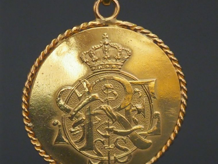 Pendentif en or jaune, serti en son centre d'une médaille d'un tournoi