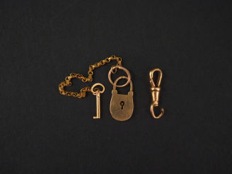 Vente aux enchères Ensemble comprenant :  - un cadenas et sa clé en or jaune. -	 un éléme