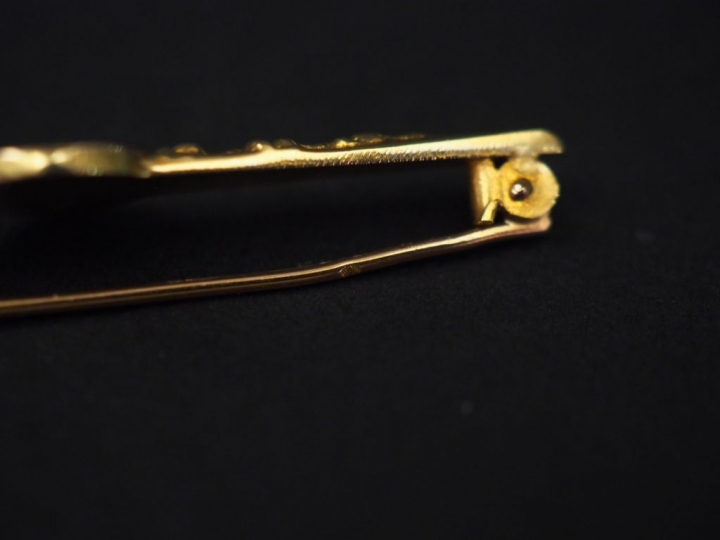 Broche barrette en or jaune, à décor d’un motif central circulaire ser