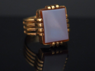 Vente aux enchères Bague en or jaune, sertie en son centre d'une pierre dure.  L'anneau f