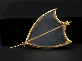 Vente aux enchères Une broche porte-photo en or jaune et verre en forme d’écu. 3,5 x 2,2 