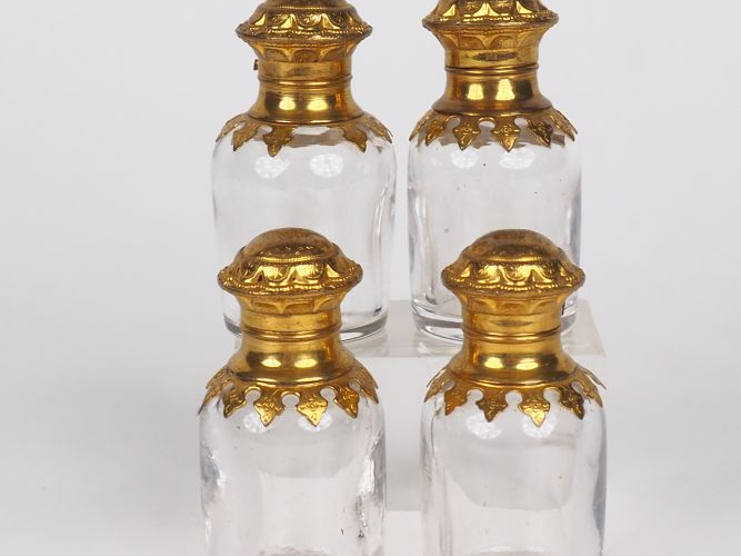 Suite de quatre flacons à odeurs en cristal et pomponne.