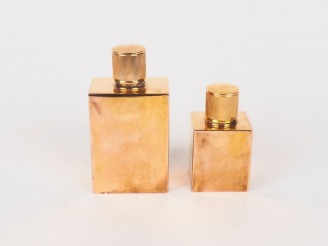 Vente aux enchères HERMES.  Deux différents flacons en métal doré. Signés. H. 11 cm et 8 