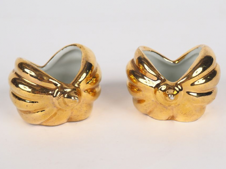 ROBJ.  Paire de salerons en porcelaine dorée en forme de coquillage.
