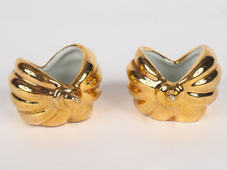 Vente aux enchères ROBJ.  Paire de salerons en porcelaine dorée en forme de coquillage.