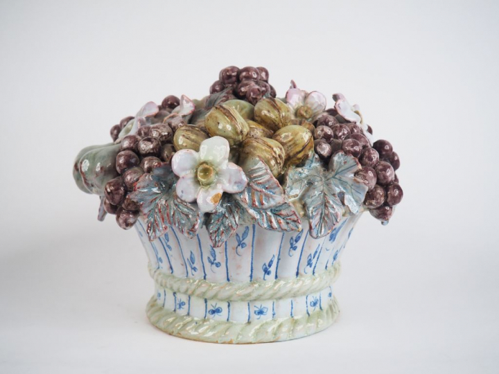 Centre de table en faïence figurant une corbeille de fruits. H. 24 cm