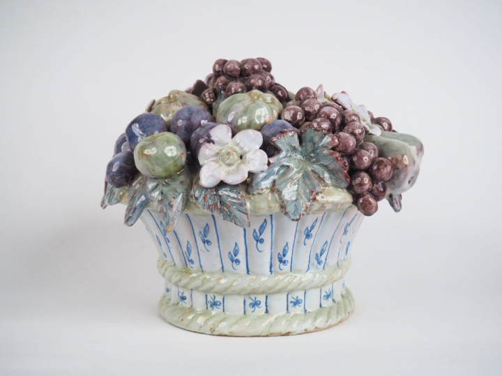 Centre de table en faïence figurant une corbeille de fruits. H. 24 cm