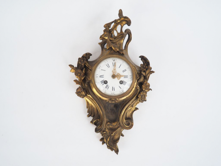 Cartel de style Louis XV en bronze, à décor de rocailles et de fleurs.