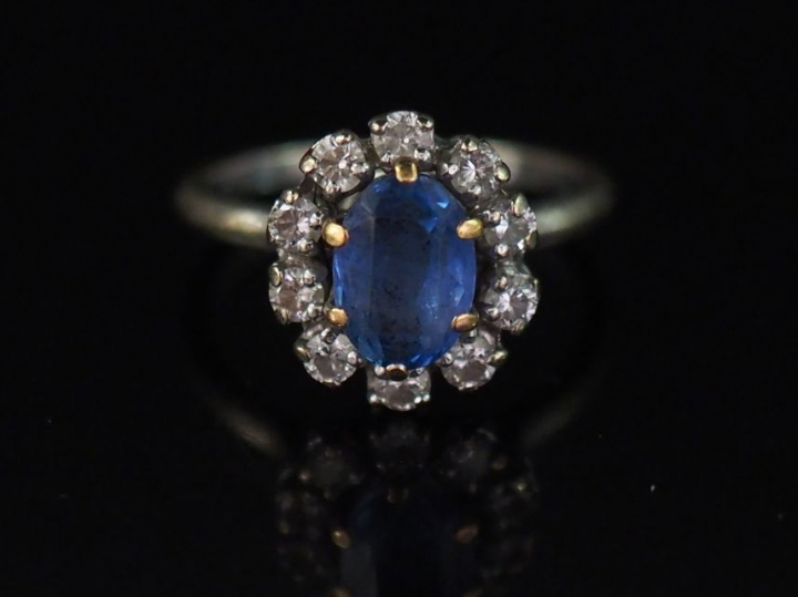 Bague marquerite en or blanc, sertie en son centre d'un saphir entouré