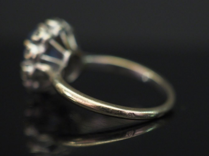 Bague marquerite en or blanc, sertie en son centre d'un saphir entouré