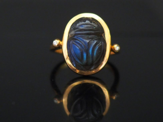 Vente aux enchères Bague en or jaune, sertie en son centre d'un scarabée en pierre dure o
