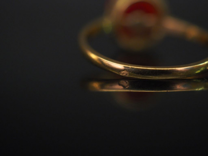 Bague en or jaune, sertie en son centre d'un corail en cabochon godron