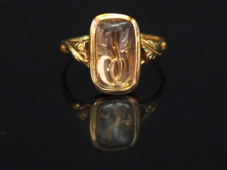 Vente aux enchères Bague en or jaune et verre, à décor de monogramme. La monture feuillag