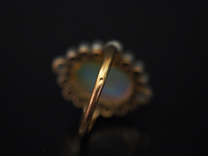 Bague en or jaune, sertie en son centre d'une opale entourée de seize 