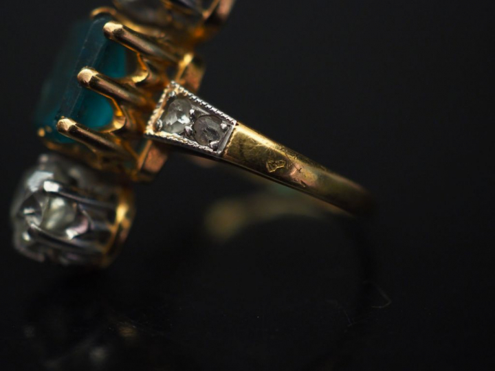 Bague marquise en or jaune, sertie en son centre d'une émeraude épaulé