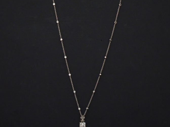 Pendentif en forme de croix et sa chaine en or blanc, sertie d'un pava