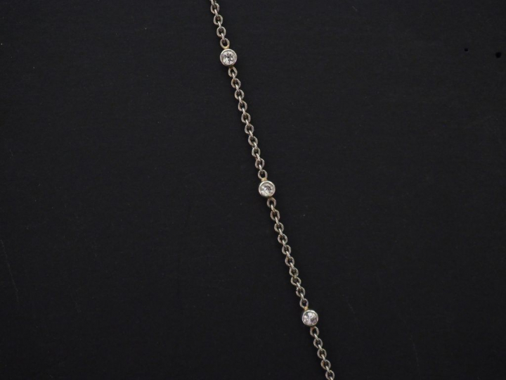 Pendentif en forme de croix et sa chaine en or blanc, sertie d'un pava