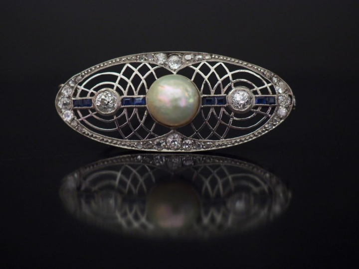 Broche ovale de style Art déco en or blanc, à décor ajouré et sertie d