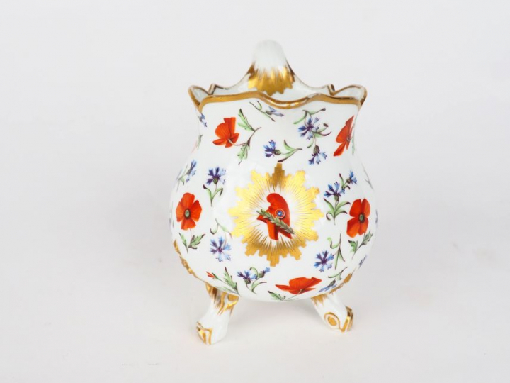 SEVRES. Pot à lait tripode en porcelaine à décor polychrome de bonnet 