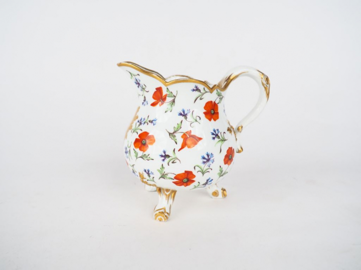SEVRES. Pot à lait tripode en porcelaine à décor polychrome de bonnet 