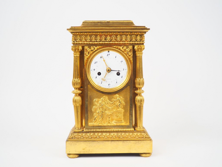 Pendule Empire en bronze doré, à décor de marchandes d’amours, de fris