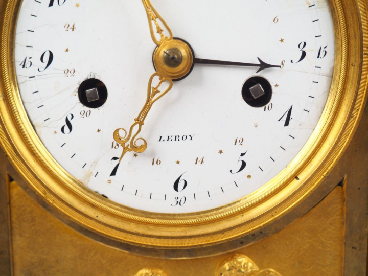 Pendule Empire en bronze doré, à décor de marchandes d’amours, de fris