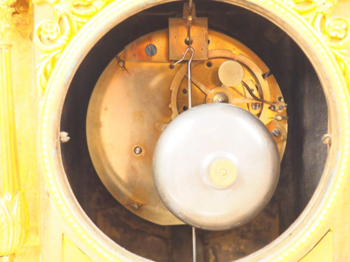 Pendule Empire en bronze doré, à décor de marchandes d’amours, de fris