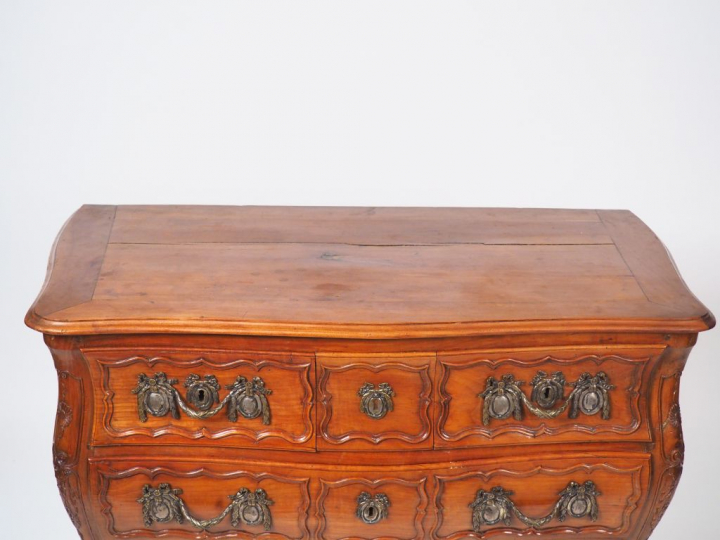Commode tombeau Louis XV en merisier mouluré et sculpté, à décor de fl