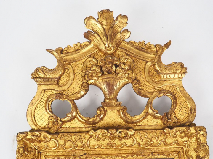 Glace Louis XV en bois sculpté et doré, à décor de rinceaux et de fleu