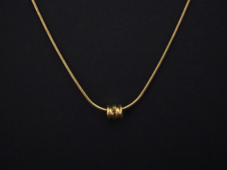 Vente aux enchères Fine chaine en or jaune, maille dite "tubogaz", à décor d'un petit pen